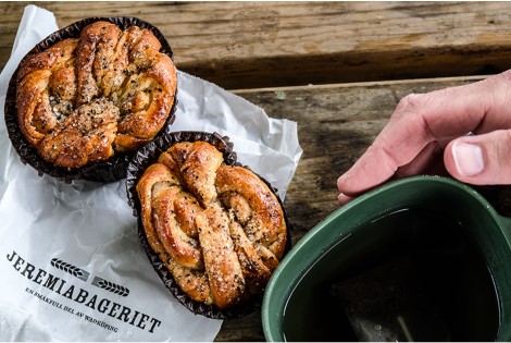 Två bullar och en grön kåsa som omfamnas av två händer.
