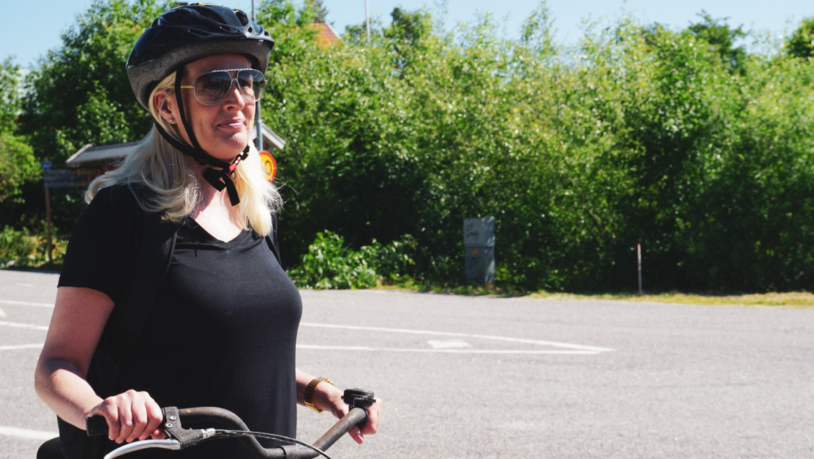 En blond kvinna med cykelhjälm.
