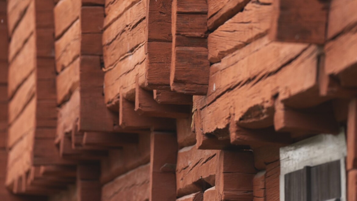 Närbild på rött timrat hus.