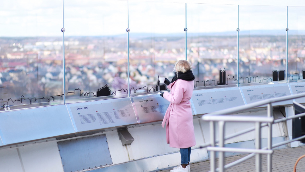 En tjej i rosa kappa och utsikt från Svampens skybar