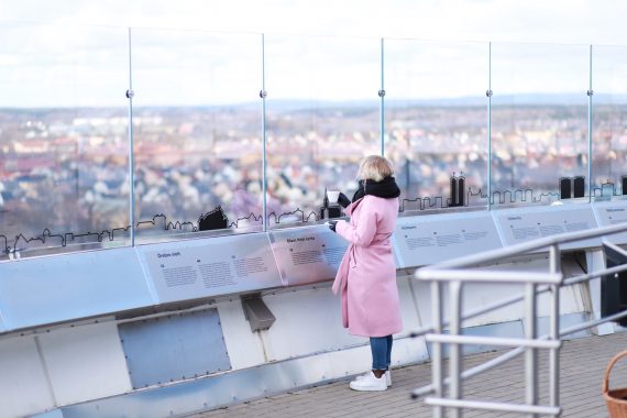 En tjej i rosa kappa och utsikt från Svampens skybar