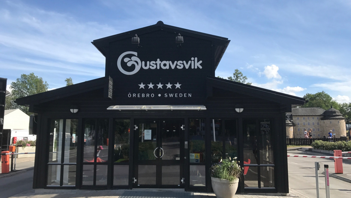 En svartmålad entré med texten Gustavsvik.