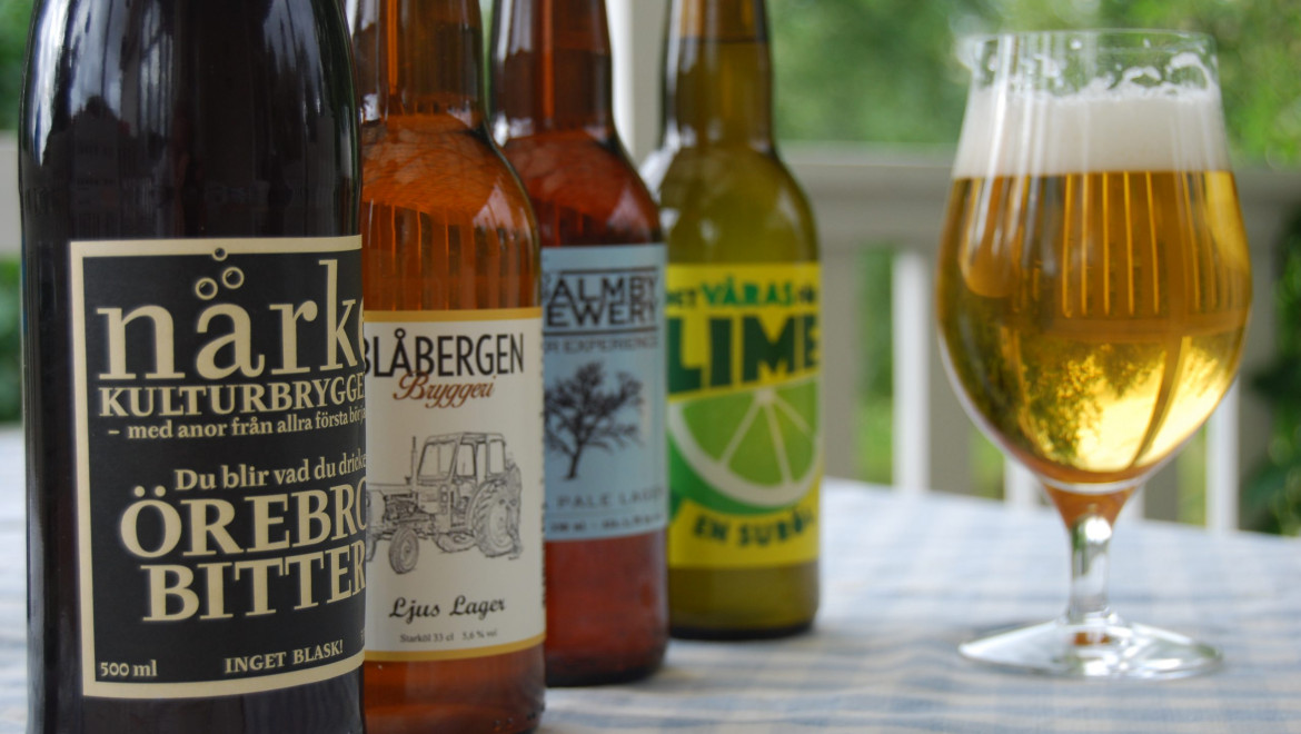 Fyra lokala ölflaskor och ett glas med öl i.