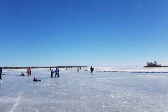 Spegelblank is på en sjö och blå himmel.