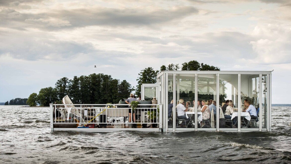 En restaurang i en glaskub flyter på vattenytan.