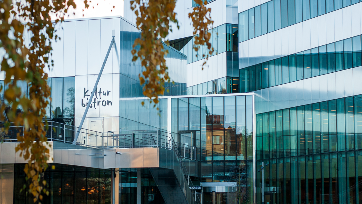 En silvrig byggnad i modern stil med höstlov fi förgrunden. Kulturkvarteret i Örebro.