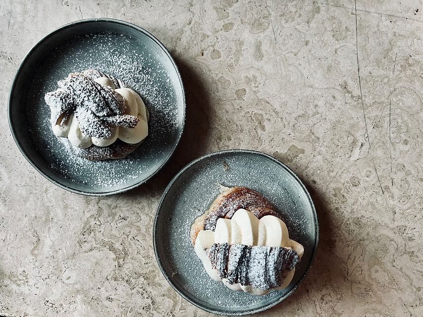 Två semlor på blå fat fotade uppifrån.